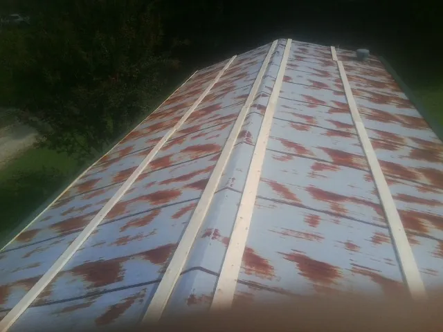 Rusted metal roof panels with new wood purlins before replacement — Storm Damage Roof Repair in North Troy by Roofing Brothers