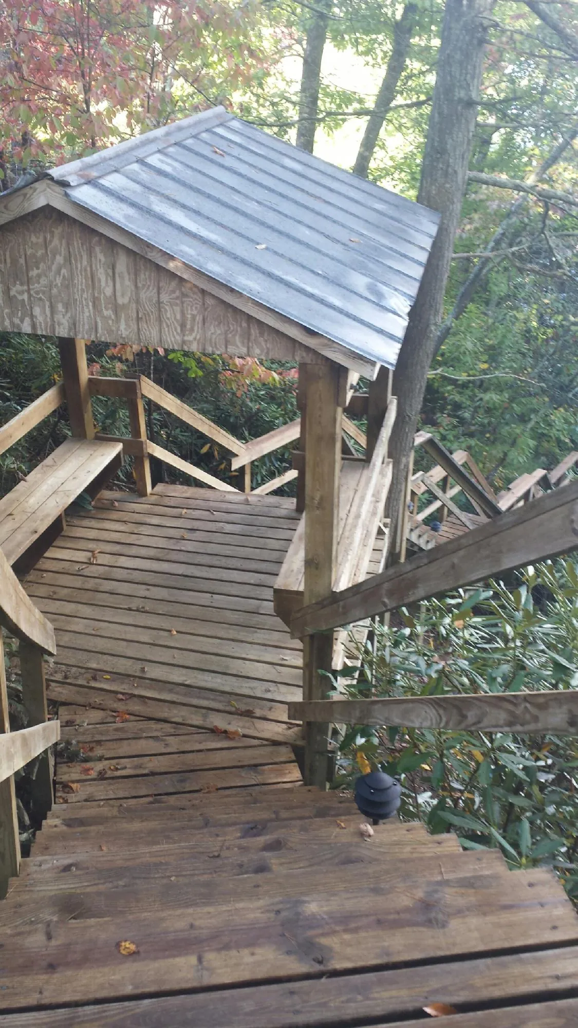 Metal roofed shelter over wooden steps on a wooded walkway — Skylight Repair & Installation work by our crew in North Troy