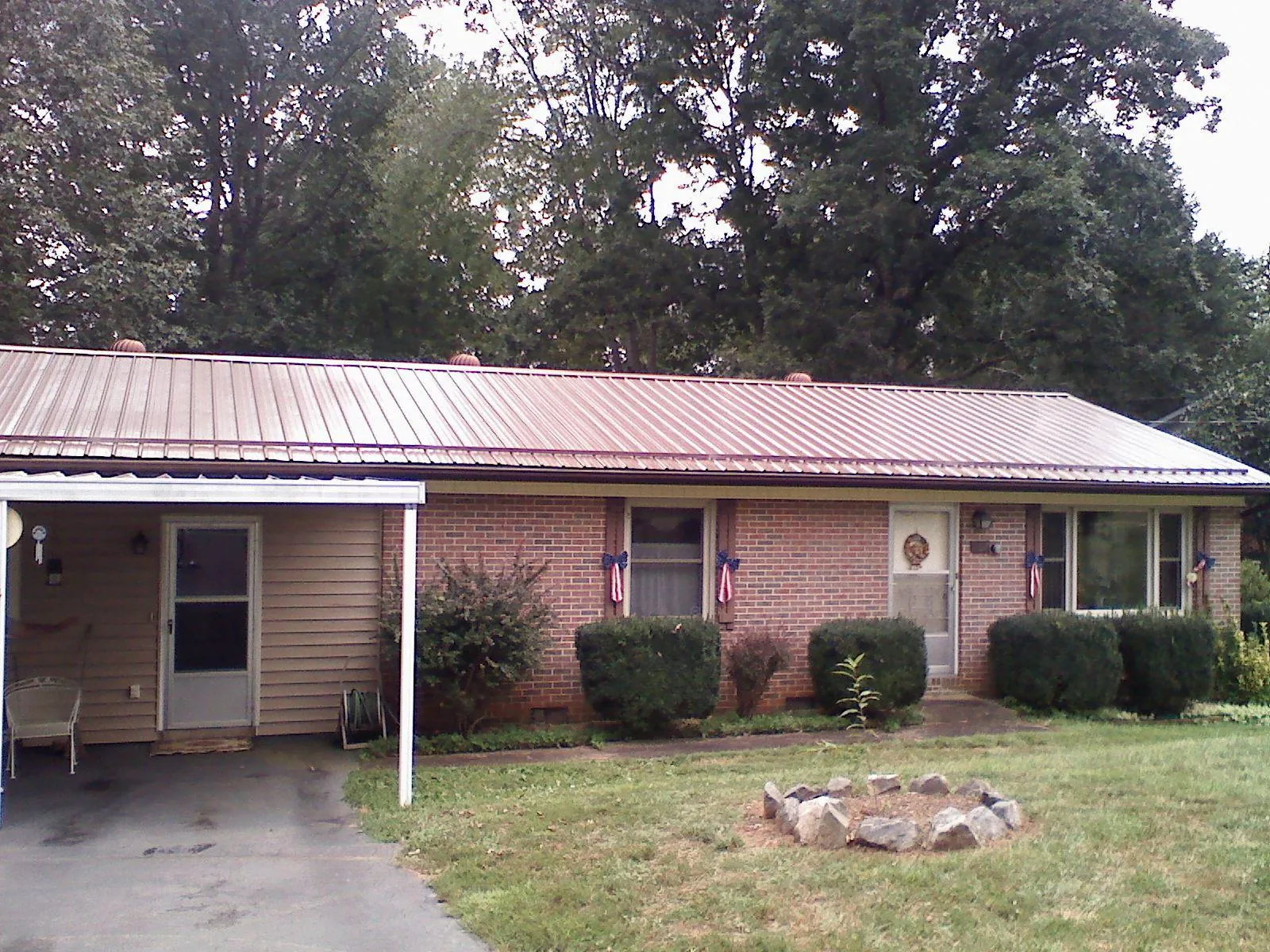 Bronze metal roof and carport on a brick ranch home — Roof Repair work by our crew in North Troy